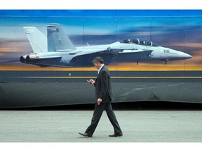 A visitor walks past the FA 18 Super Hornet display as the annual trade fair for military equipment known as CANSEC took place at the EY Centre near the airport. Photo taken at 10:42 on May 28, 2014.