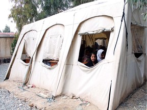 Afghan schoolgirls sit in a tent as they attend class in Kandahar on May 1, 2014. The literacy rate in Afghanistan is about 30 percent and about 42 percent of the country's population is under the age of 14. According to UNICEF more boys than girls attend classes in primary school in Afghanistan.