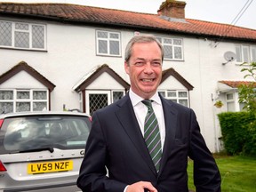 UK Independence Party (UKIP) leader Nigel Farage poses for photographers as he leaves his home in Kent on May 26, 2014, ahead of a press conference in central London.  The anti-EU mood in Europe swept Britain On May 26 as the UK Independence Party (UKIP) looked set to score a historic victory in the European parliament elections.