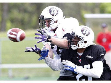 Bryce Lawrence (L) attempts a catch while Eddie Elder blocks him at the CFL Ottawa Redblacks rookie camp at Keith Harris Stadium in Ottawa on Friday May 30, 2014.