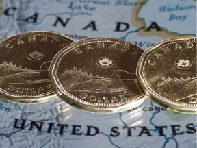 Canadian dollar coins, or Loonies, are displayed on a map of North America January 9, 2014 in Montreal.