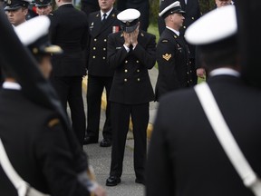 A member of the Canadian Armed Forces holds his head in his hands during a National Day of Honour Ceremony at the Canadian Forces Base Esquimalt in Esquimalt, B.C. Friday May 9, 2014. THE CANADIAN PRESS/Chad Hipolito