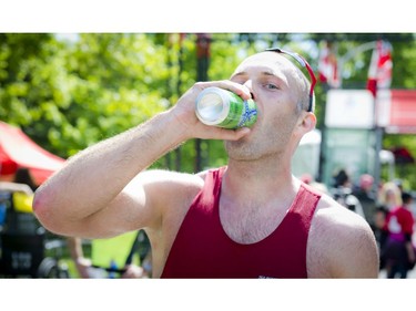 Chris Smith cracks a beer after finishing the 1/2 marathon at Ottawa Race Weekend Sunday May 25, 2014.