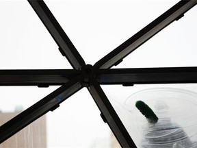 A man cleans a window at the Ottawa Convention Centre on Saturday, May 3, 2014.