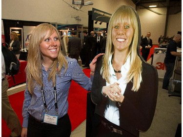 Elise Foran of 3M Canada looks at a plexiglass version of herself that's projected onto the 3M Vikuiti Rear Projection Film mounted on the back as the annual trade fair for military equipment known as CANSEC took place at the EY Centre near the airport.