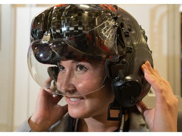 Erika Strong tries on the F35 Lightning fighter helmet that allows the pilot to see all around the jet when in flight as the annual trade fair for military equipment known as CANSEC took place at the EY Centre near the airport.