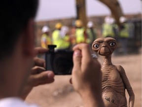 A man takes a photo of an E.T. doll in Alamogordo, N.M, Saturday, April 26. Producers of a documentary dug in an southeastern New Mexico landfill in search of millions of cartridges of the Atari 'E.T. the Extra-Terrestrial' game that has been called the worst game in the history of video gaming and were buried there in 1983.