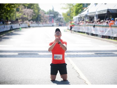 Felix Seguin falls to his knees after finishing the marathon at Ottawa Race Weekend Sunday May 25, 2014.