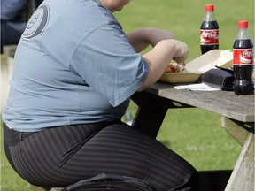 FILE- In this file photo dated Wednesday, Oct. 17, 2007, an overweight person eats in London, Wednesday, Oct. 17, 2007.  Almost a third of the world population is now fat, and no country has been able to curb obesity rates in the last three decades, according to a new global analysis released Thursday May 29, 2014,  led by Christopher Murray of the Institute for Health Metrics and Evaluation at the University of Washington, USA, and paid for by the Bill & Melinda Gates Foundation.  Researchers reviewed more than 1,700 studies covering 188 countries covering over three decades and found more than 2 billion people worldwide classified as overweight or obese. The highest rates of obesity were found in the Middle East and North Africa, with the U.S. having about 13 percent of the world�s fat population.