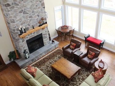 Looking down from the loft, the soaring stone fireplace in the Johnson home dominates the space.