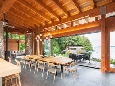 This Muskoka cottage features a retractable sliding glass door system that turns the open living space into a porch. Motorized screens keep bugs out.