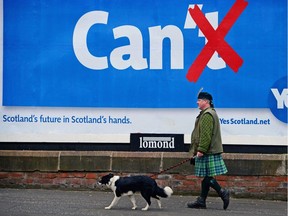 Colin MacDonald Provan walks his dog Colleen down Glasgow High Street past a Yes referendum campaign billboard On May 20, 2014 in Glasgow, Scotland.