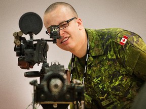 Gunner Alex Desouza checks the sights on a Browning 50 calibre M2 machine gun as the annual trade fair for military equipment known as CANSEC took place at the EY Centre near the airport.
