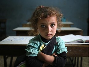 In this picture taken on Thursday, May 29, 2014, a Syrian refugee girl sits in a classroom at a Lebanese public school where only Syrian students attend classes in the afternoon, at Kaitaa village in north Lebanon. More than 1.1 million Syrian refugees are now living in Lebanon.