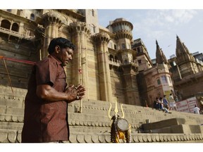 An Indian resident prays at sunrise on a ghat on the banks of the River Ganges in the old part of Varanasi on May 11.