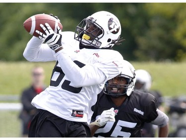 Jason Bruce (L) catches the ball while Brandyn Thompson chases him at the CFL Ottawa Redblacks rookie camp at Keith Harris Stadium in Ottawa on Friday May 30, 2014.