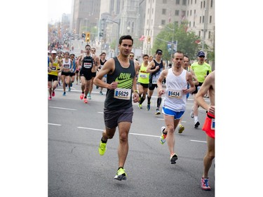 From left, Christopher Aranda and Ryan Mullally make their way up Elgin Street as marathoners start the race during Ottawa Race Weekend Sunday May 25, 2014.