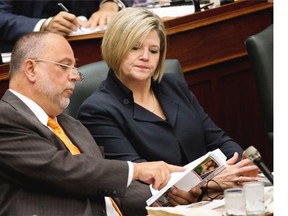 NDP leader Andrea Horwath, right, and Gilles Bisson, left, read the 2014 Ontario budget as Ontario Finance Minister Charles Sousa, not shown, delivers the 2014 budget at Queen’s Park in Toronto on Thursday, May 1, 2014.