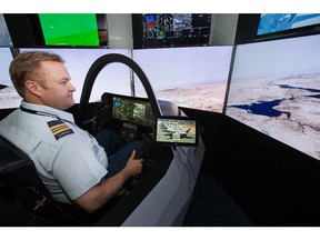 Major Donald Couzens checks out the F35 cockpit simulator as the annual trade fair for military equipment known as CANSEC took place at the EY Centre near the airport. Photo taken at 10:09 on May 28, 2014.