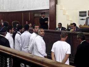 Al-Jazeera English bureau chief Mohamed Fahmy, center, in a courtroom in Cairo, March 31, 2014. The family of an Egyptian-Canadian journalist who has been detained in a Cairo prison since late December says they have met with Foreign Affairs Minister John Baird.