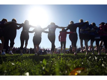 Mothers, daughters, and other family and friends take part in a stretch prior to the Shoppers Drug Mart Run for Women on Sunday, May 11, 2014 near the Aviation Museum. The 5K. 10K, and 1k for children helps raise money for Women's Mental Health programs in race cities, such as Royal Ottawa.