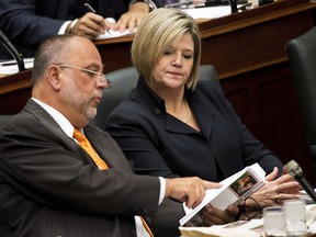 NDP leader Andrea Horwath, right, and Gilles Bisson, left, read the 2014 Ontario budget as Ontario Finance Minister Charles Sousa, not shown delivers the 2014 budget at Queen's Park in Toronto on Thursday, May 1, 2014.THE CANADIAN PRESS/Nathan Denette