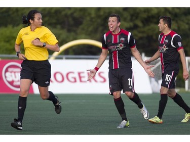 Ottawa Fury Oliver Minatel (Centre) argues with the referee during the teams match-up at Keith Harris Stadium in Ottawa, May 31, 2014.