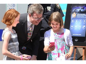 Grade four students, Keira McCrory (left) and Maya Lavictoire, gets "selfies" with Ottawa Mayor Jim Watson. 
The Ottawa police kicked off Police Week at the Elgin Street headquarters Monday with a BBQ and the launch of their new Ottawa Police Service App.