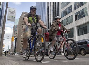 Bike commuters head home via the Laurier Avenue bike lane on Thursday, May 22.