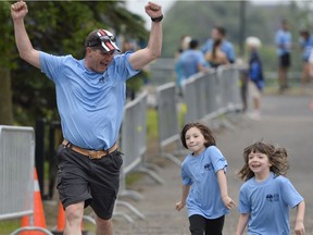 Stephane Girard and his nieces Annabelle, left, and Lily Girard, right, dashes toward the finish line at the Ultimate Run for Men's Cancers, Ottawa's biggest Father's Day fundraiser held at the Anniversary Park June 16, 2013.