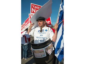 OTTAWA, ONT.: MAY 7, 2014 -- Guy Annable,  wearing a barrel to protest the Liberals, at the campaign office opening event for Ottawa South Liberal MPP John Fraser at 1652 Bank Street in Ottawa, Ontario, May 7, 2014. Ontario Premier and Leader of the Ontario Liberal Party Kathleen Wynne attended the event. John Fraser is running for re-election in the June 12th Ontario provincial election. (Garth Gullekson / The Ottawa Citizen / Postmedia News) (For story by David Reevely) NEGATIVE NO:  xxxxxx