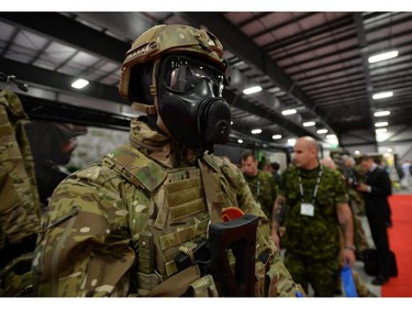People make their way past a display at the CANSEC trade show in Ottawa on Wednesday, May 28, 2014. The bombs and mortars on display are models.