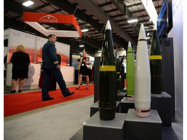 People make their way past a display of bombs at the CANSEC trade show in Ottawa on Wednesday, May 28, 2014. The bombs and mortars on display are models.