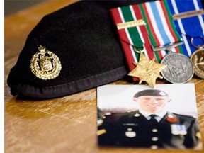 A photo of Cpl. Stuart Langridge is seen along with his beret and medals on a table during a 2010 news conference on Parliament Hill.