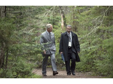 Prince Charles walks with P.E.I. Assistant Deputy Minister of Environment Todd Dupuis on Tuesday, May 20, 2014 in Bonshaw, P.E.I. The Royal couple is on a four-day tour of Canada.