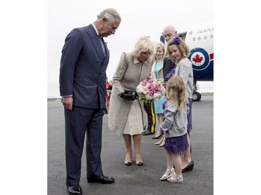 Prince Charles and his wife Camilla are presented with flowers by three-year-old Grace Elizabeth Lenihan and her nine-year-old sister Molly Jane as they arrive Sunday, May 18, 2014 in Halifax. The Royal couple begin a four-day tour of Canada.