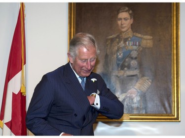 Prince Charles reaches for his pen to sign the registry after being sworn in as a member of the Privy Council in Halifax on Sunday, May 18, 2014. The Royal couple begin a four-day tour of Canada.