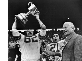 A milestone memory: Moe Racine (#62) hoists the 1973 Grey Cup, with Wayne Giardino (#21) and Governor General Roland Michener after Ottawa Rough Riders win the Grey Cup game against the Edmonton Eskimos 22-18 at Toronto on Nov. 25, 1973.