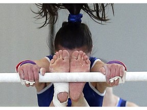 Raquel Tonn runs through her uneven bars routine as her team from Alberta looks on. Gymnasts practiced with their provincial teams as the 2014 Canadian Gymnastics Championships were kicked off at Carleton University Tuesday, May 27, 2014.