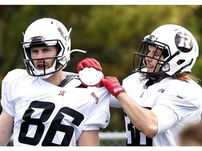 Robin Medeiros (R) adjusts the pads of Simon Le Marquand at the CFL Ottawa Redblacks rookie camp at Keith Harris Stadium in Ottawa on Friday May 30, 2014.