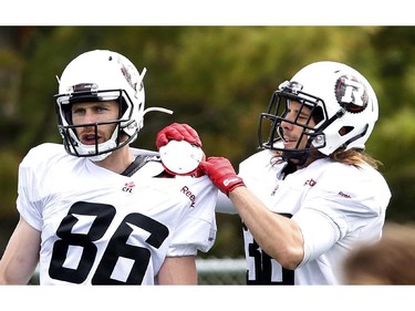 Robin Medeiros (R) adjusts the pads of Simon Le Marquand at the CFL Ottawa Redblacks rookie camp at Keith Harris Stadium in Ottawa on Friday May 30, 2014.