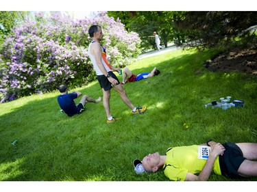 Runners stretch and relax on the grass after finishing the marathon at Ottawa Race Weekend Sunday May 25, 2014.