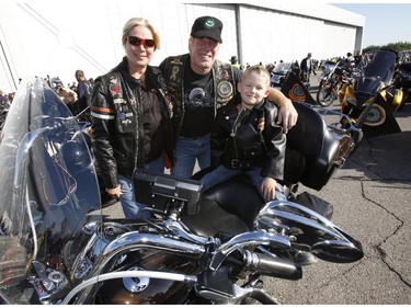 Samuel Parent, 5, and his dad Michel Parent and Helene Girard from Quebec City pose for a photo at the start of the Ottawa TELUS Motorcycle Ride for Dad at the Canadian Aviation and Space Museum on Saturday May 31, 2014.