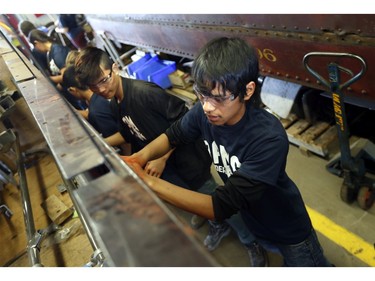Sang Thang Plong, 15, a Rideau High School shop student, with other help volunteers restore a 1917 Ottawa streetcar at the OC Transpo's Merivale garage Friday, May 23, 2014. The 696 Restoration group hopes the streetcar will be fully restored and operational by 2017, in time for its 100th anniversary, the city's 150th anniversary and the unveiling of Ottawa's new Light Rail.