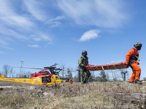 Search and rescue technicians (SAR techs) attend to casualties, played by actors, during Tigerex 2014 at Mont Cascades Ski Resort in Cantley, Que. on Tuesday, May 6, 2014.
