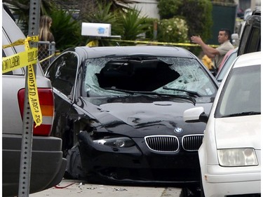 A policeman talks with a woman near the car of the shooting suspect that went on a killing rampage at the University of California at Santa Barbara college town of Isla Vista, California, USA, 24 May 2014.  The suspect killed six people and wounded seven as he drove through the college town shooting as well as running over victims in his car before he died either in the shoot-out with police or from a self-inflicted wound.