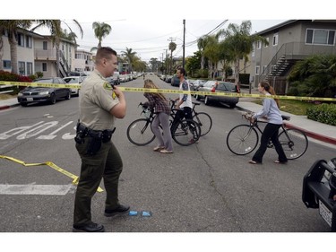 Young people pass by a policeman who has been deployed at one of the nine crime scenes where a man went on a killing rampage at the University of California at Santa Barbara college town of Isla Vista, California, USA, 24 May 2014. The suspect killed six people and wounded seven as he drove through the college town shooting as well as running over victims in his car before he died either in the shoot-out with police or from a self-inflicted wound.