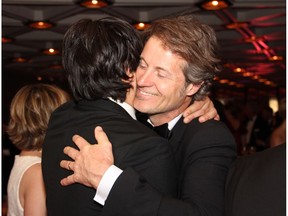 Singer-songwriter Jim Cuddy from Blue Rodeo gets a hug from Jian Ghomeshi at the Governor General's Performing Arts Awards Gala held at the National Arts Centre on Saturday, May 10, 2014.