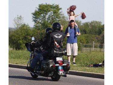 Spectators cheer on motorcyclists at the Ottawa TELUS Motorcycle Ride for Dad at the Canadian Aviation and Space Museum on Saturday May 31, 2014.