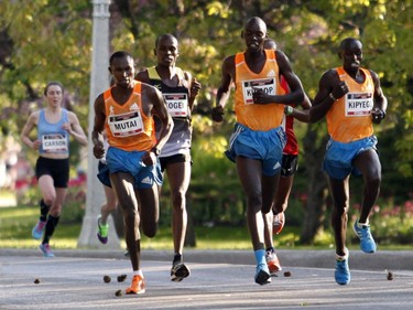 The top men runners, including the winner Wilson Kiprop, pass the women runners in the 10k race during the Ottawa Race Weekend on Saturday May 24, 2014. (Patrick Doyle / Ottawa Citizen)  ORG XMIT: 0526 ottawa10k20